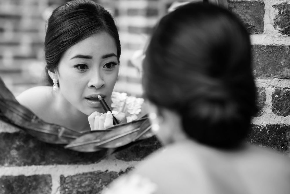 Bride applying lipstick on her wedding day in Akron, Ohio.