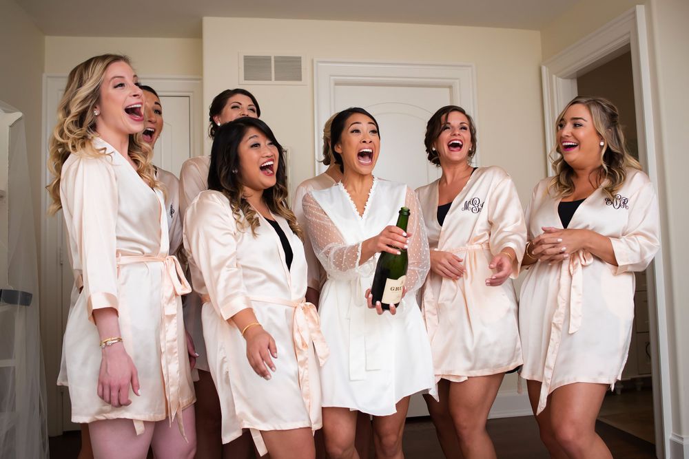 Bride and bridesmaids pop champagne on wedding day in Akron, Ohio.