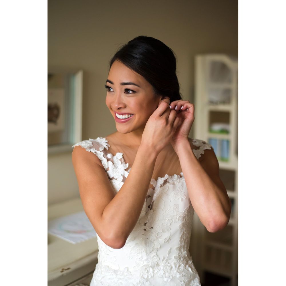 Bride adjusts earrings on wedding day in Akron, Ohio.