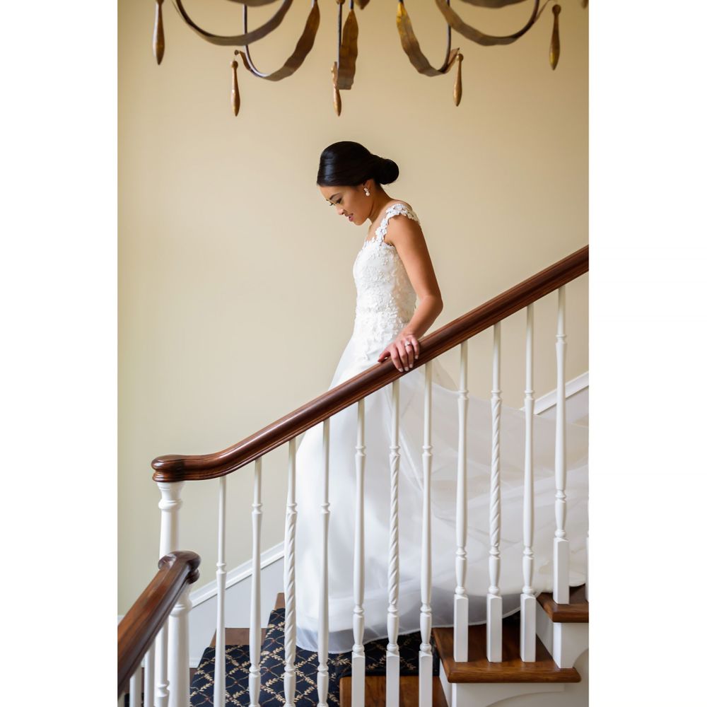 Bride walks down staircase on wedding day in Akron, Ohio.