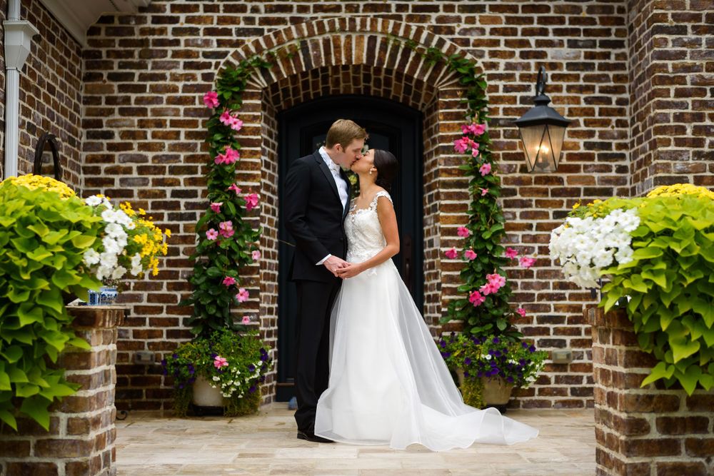 Bride and groom embrace on porch before wedding in Akron, Ohio.
