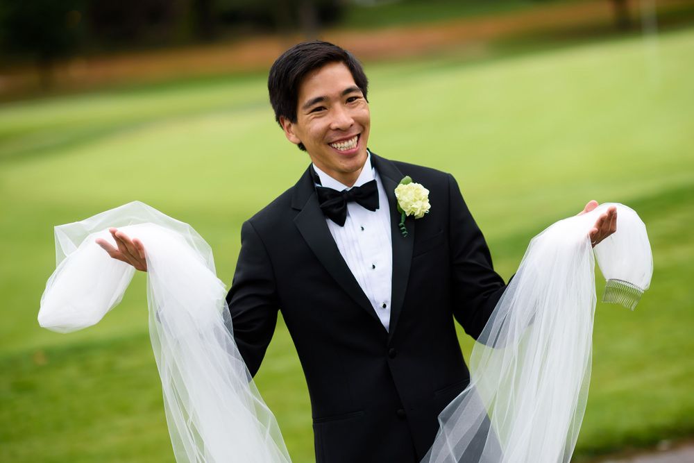 Brother of bride helps with veil on wedding day at Fairlawn Country Club in Akron, Ohio.
