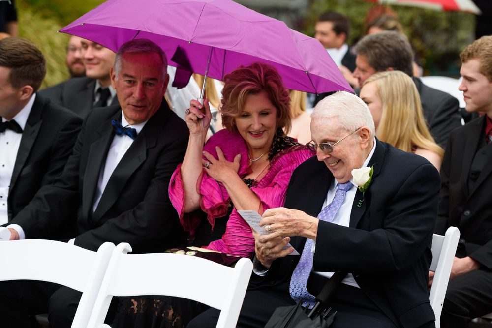 Guests read ceremony program on wedding day at Fairlawn Country Club in Akron, Ohio.