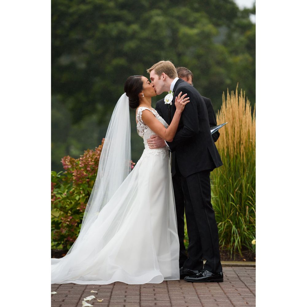 bride and groom kiss during outdoor wedding ceremony at Fairlawn Country Club in Akron, Ohio.