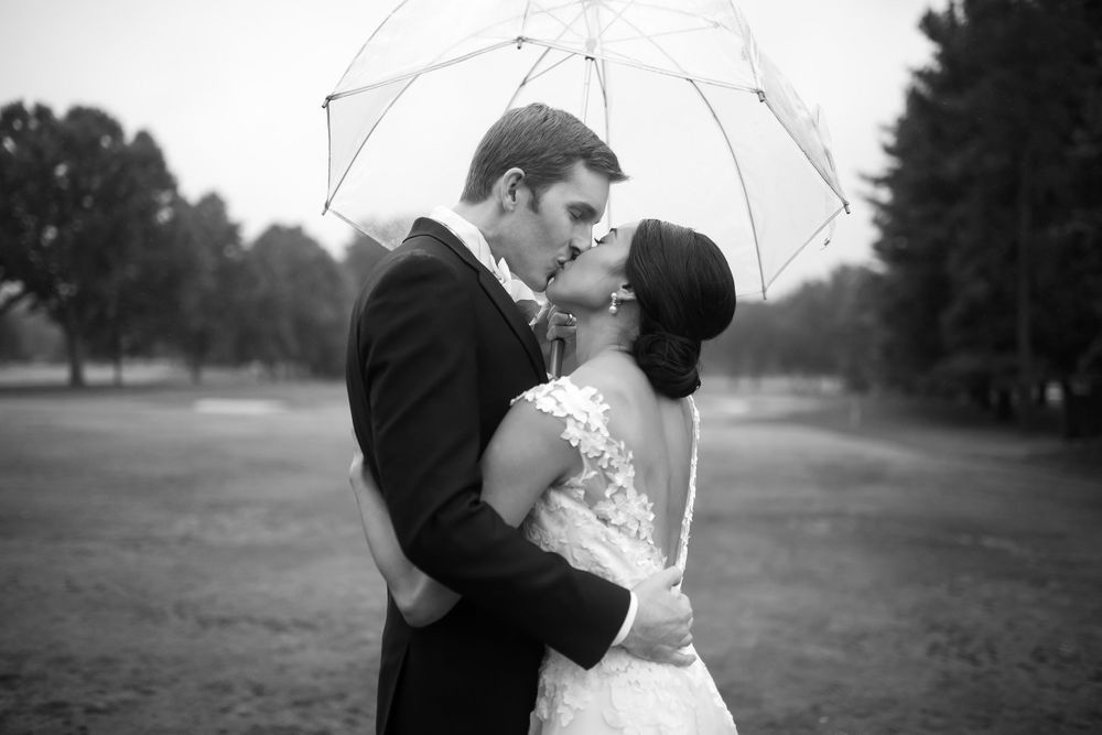Bride and groom under umbrella during wedding at Fairlawn Country Club in Akron, Ohio.