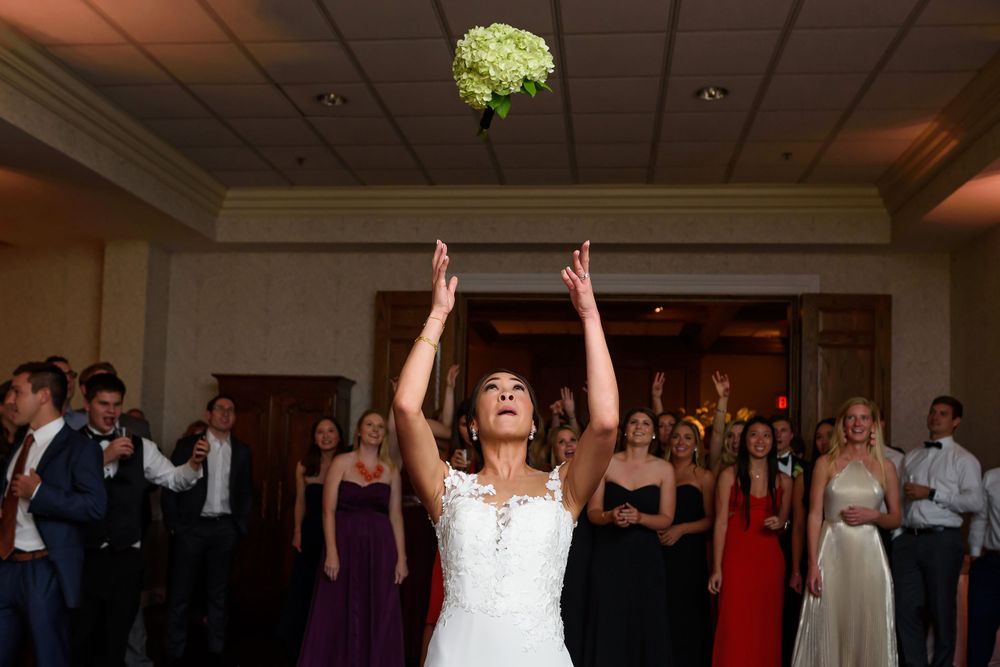 Bride tosses bouquet during wedding reception at Fairlawn Country Club in Akron, Ohio.