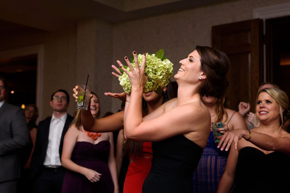 Bridesmaid catches bouquet during wedding reception at Fairlawn Country Club in Akron, Ohio.