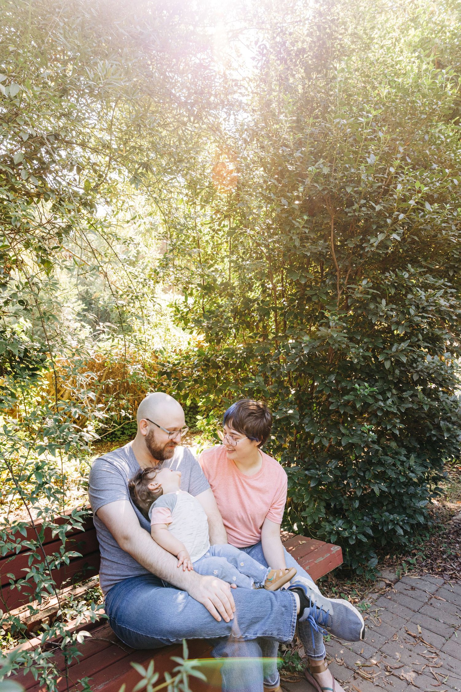 A father, mother, and daughter sit outside in their Charlotte, NC garden