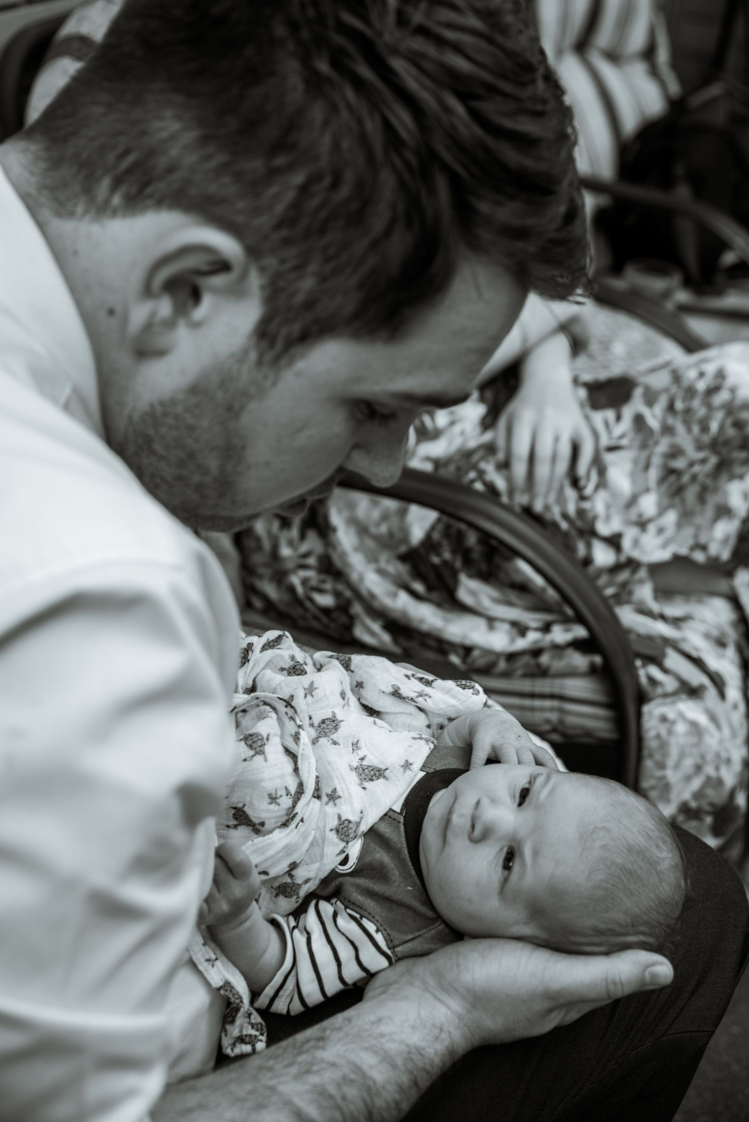 A gentle moment between a caregiver and infant in black and white.