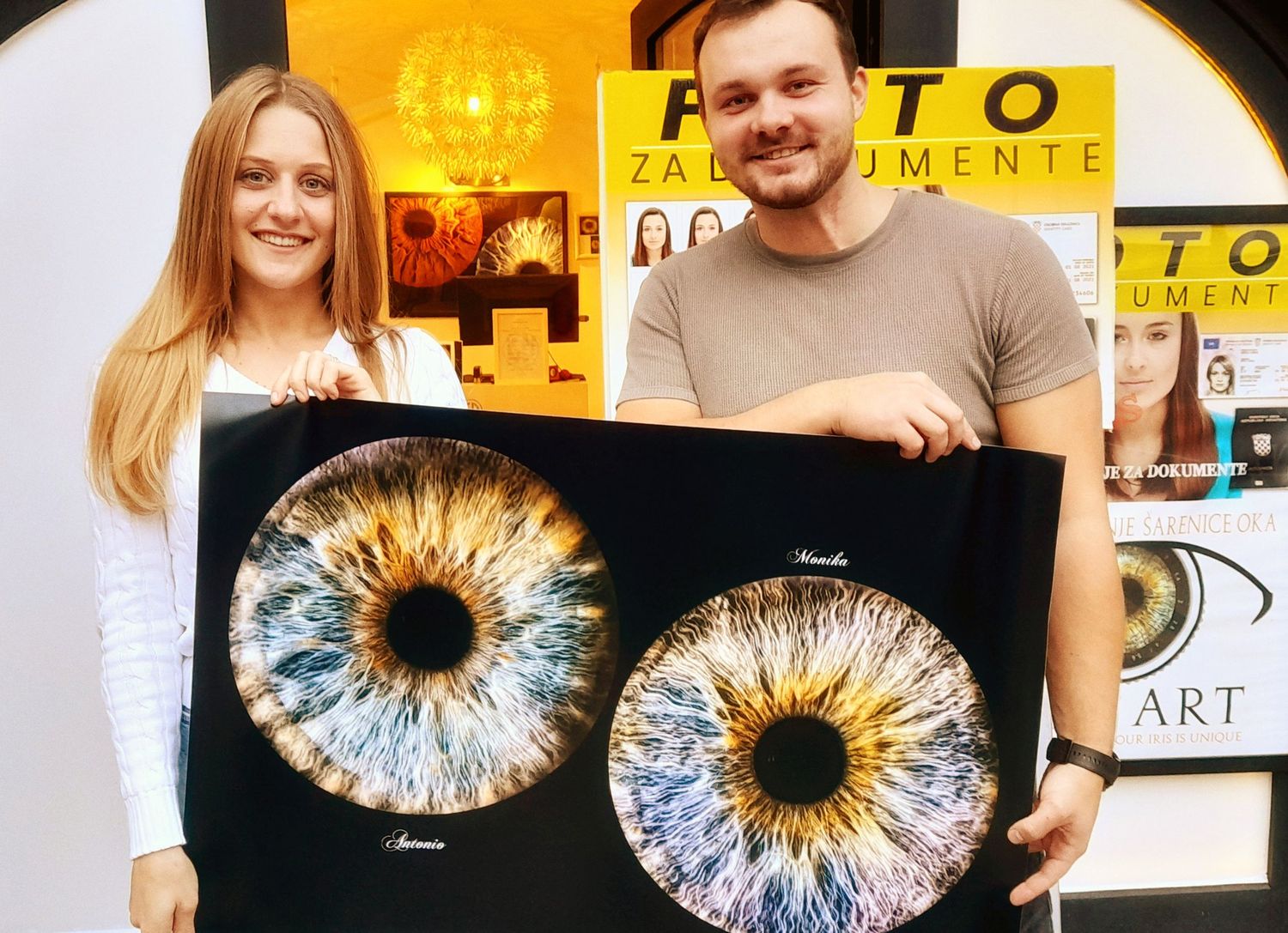 Art display featuring two large eye photography prints in yellow-lit gallery setting.