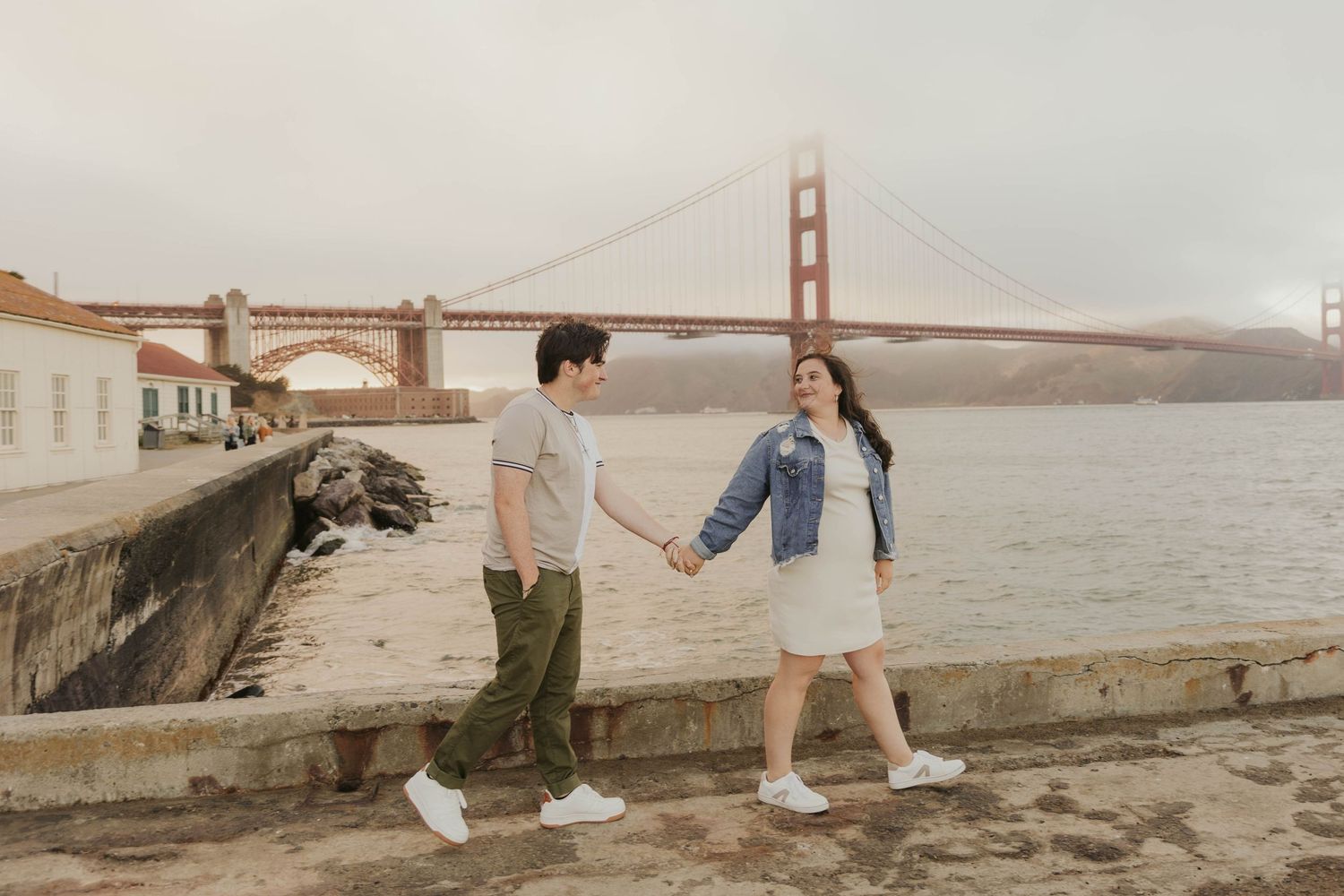 Couple strolling near the iconic Golden Gate Bridge in San Francisco.