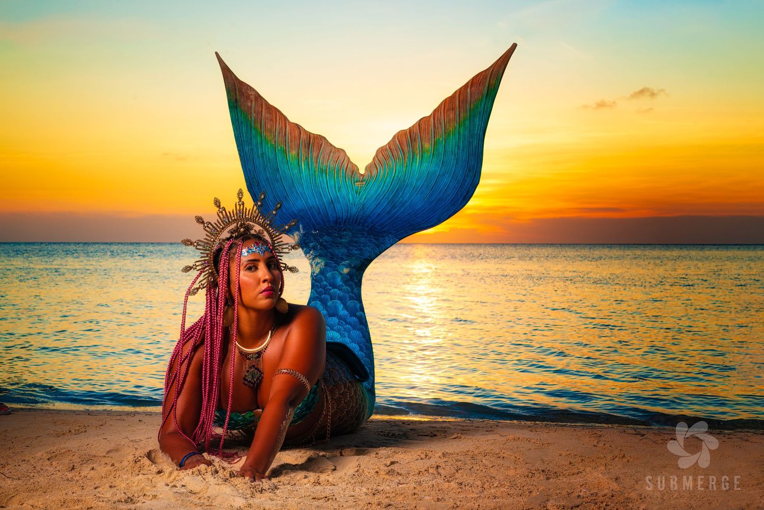 Artistic beach portrait featuring vibrant turquoise mermaid tail silhouetted against golden sunset.