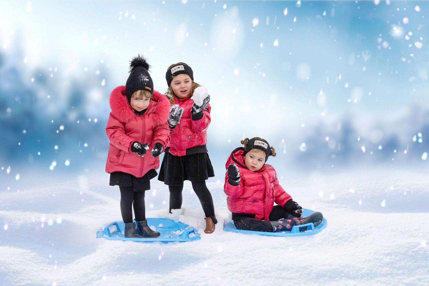Three children in bright pink winter coats sledding together in snowy winter weather.