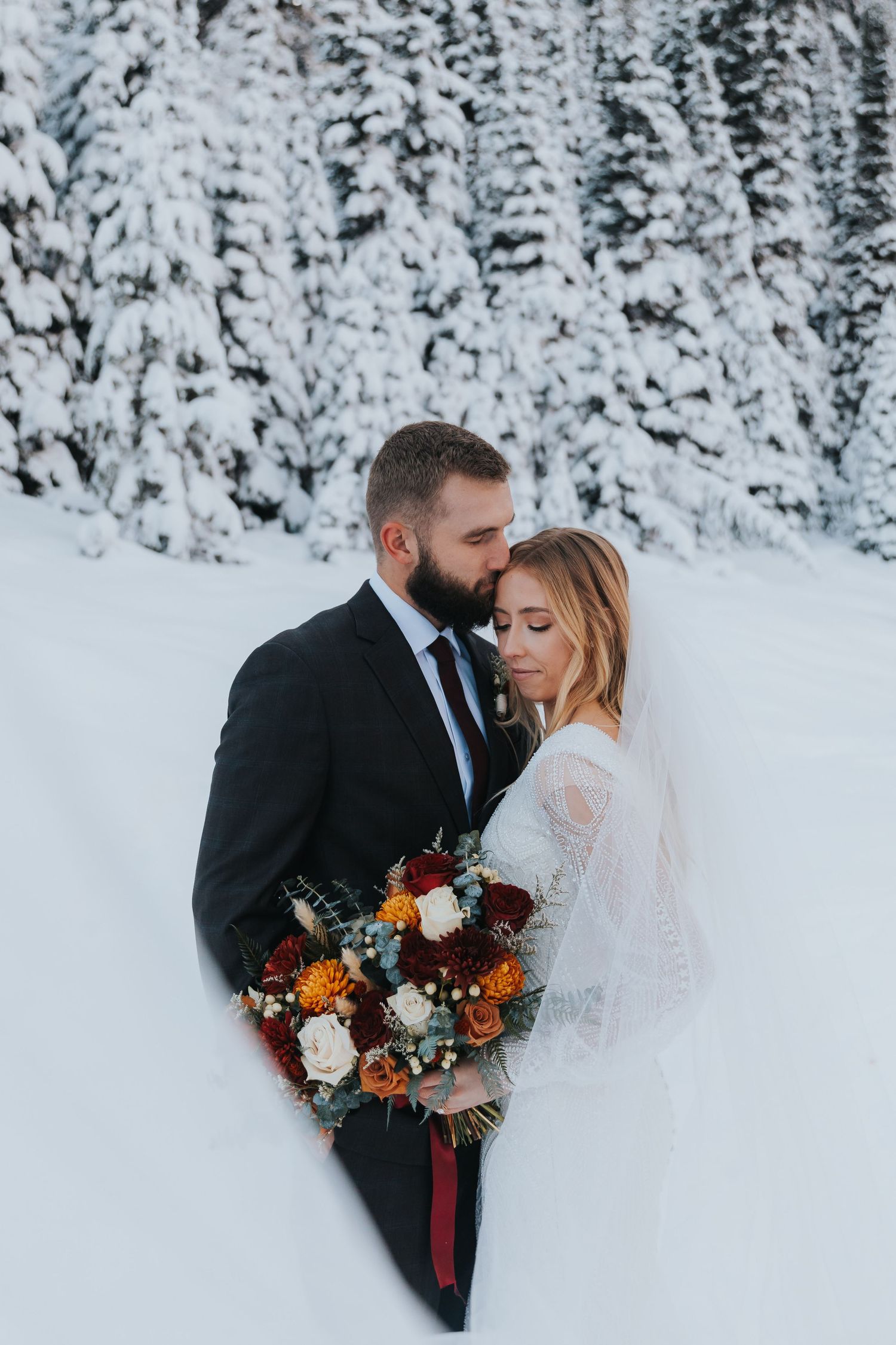 Bride and groom in the snowy pines of Park City, Utah during their luxury winter wedding