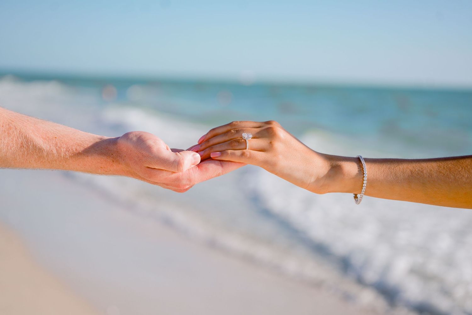 two hands touching at the beach in florida