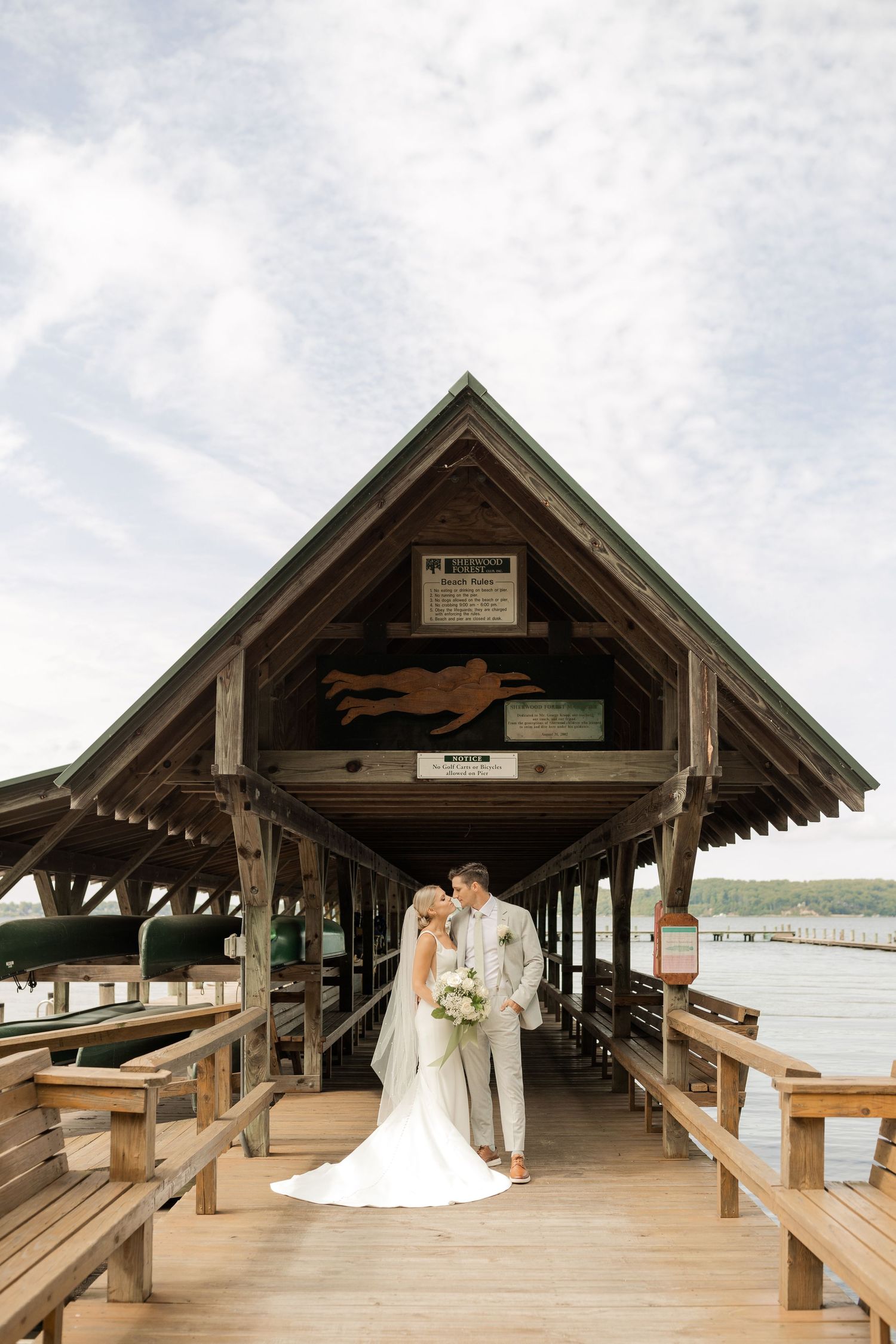 Couple shares romantic moment on rustic wooden dock overlooking lake.