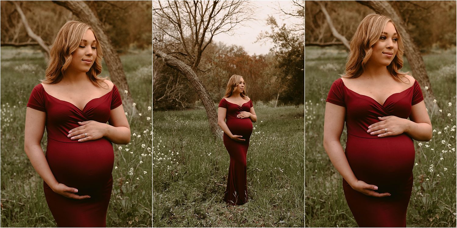 Maternity photo session in nature featuring an expectant mother wearing a burgundy dress in a field of wildflowers.