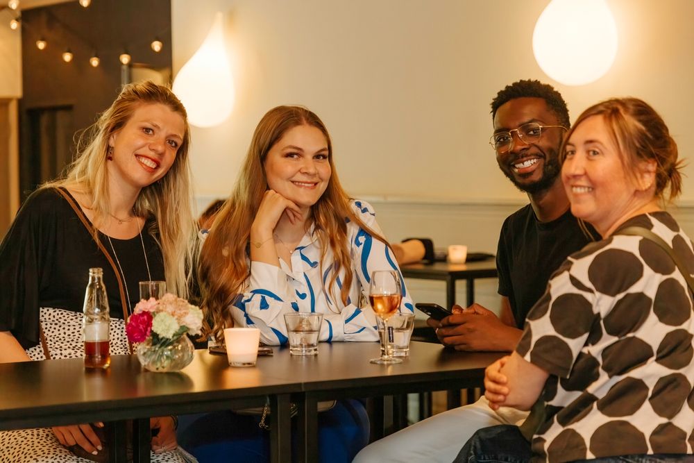 Friends enjoying drinks and conversation at restaurant table.