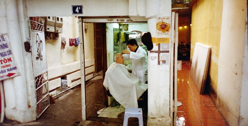 A glimpse into a simple barber shop through an open doorway in Vietnam.