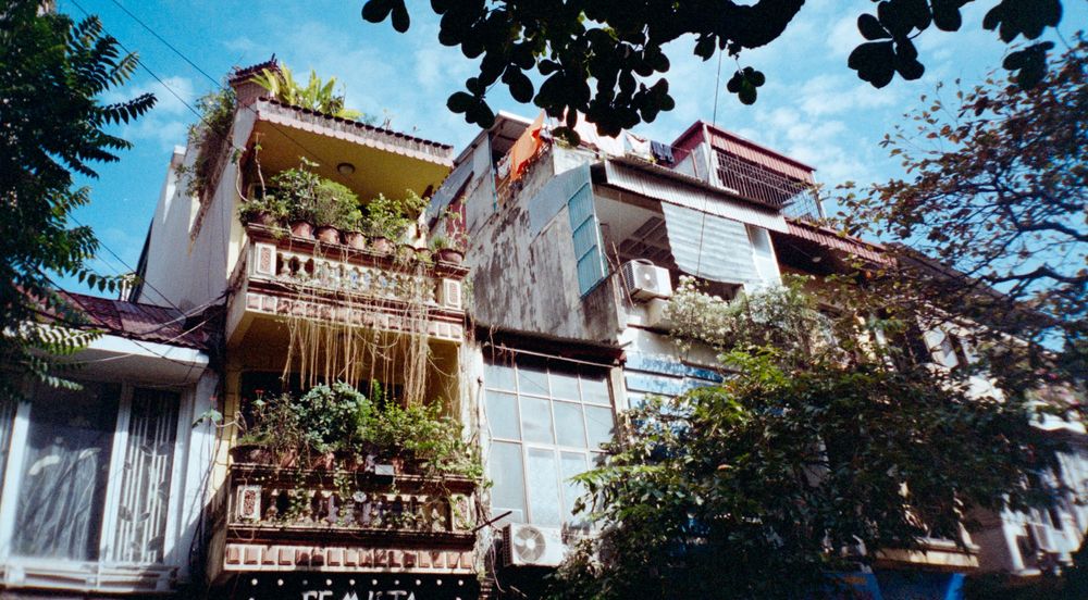 Traditional Asian architecture with ornate balconies and white facades under blue sky.