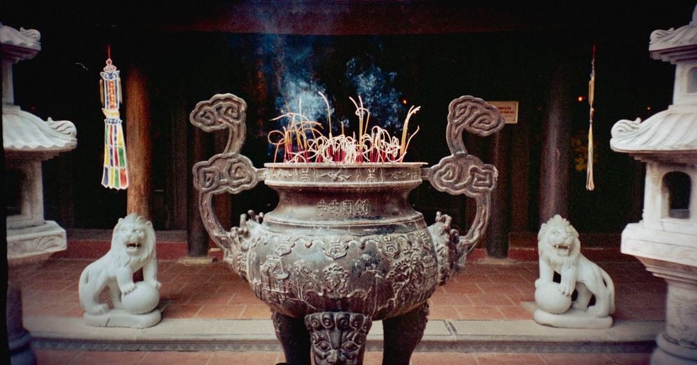 Ancient incense burner with stone guardian lions in a traditional Asian temple.
