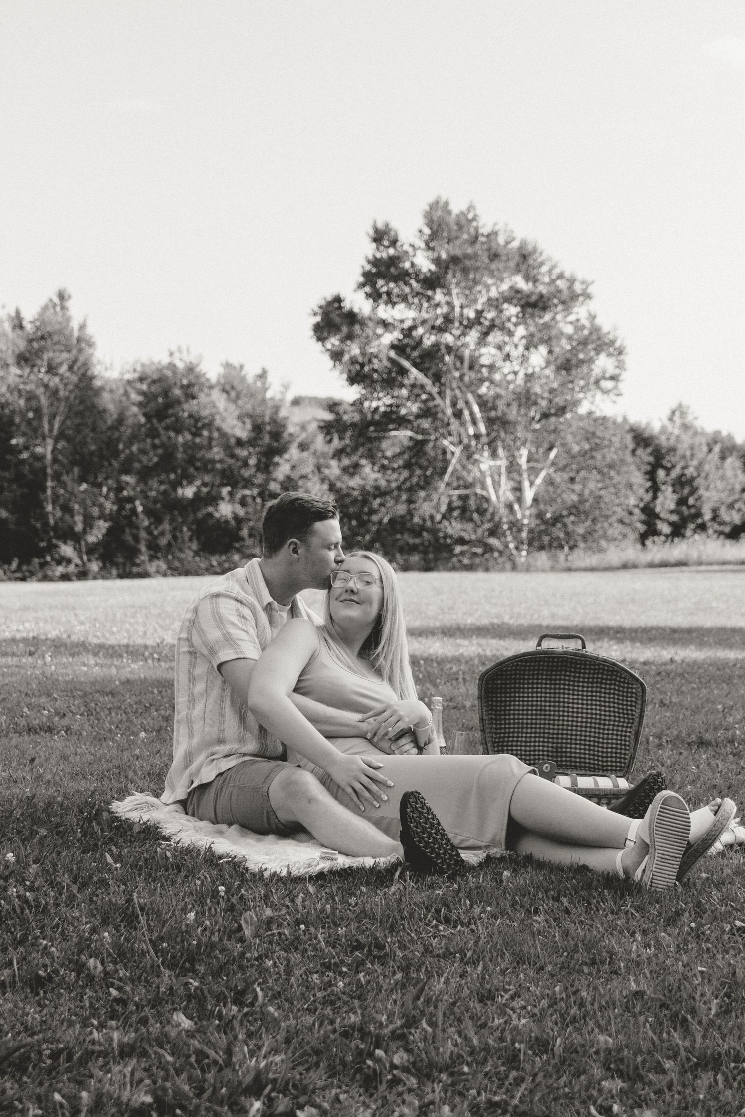 Black and white photo of a romantic picnic scene on a blanket.