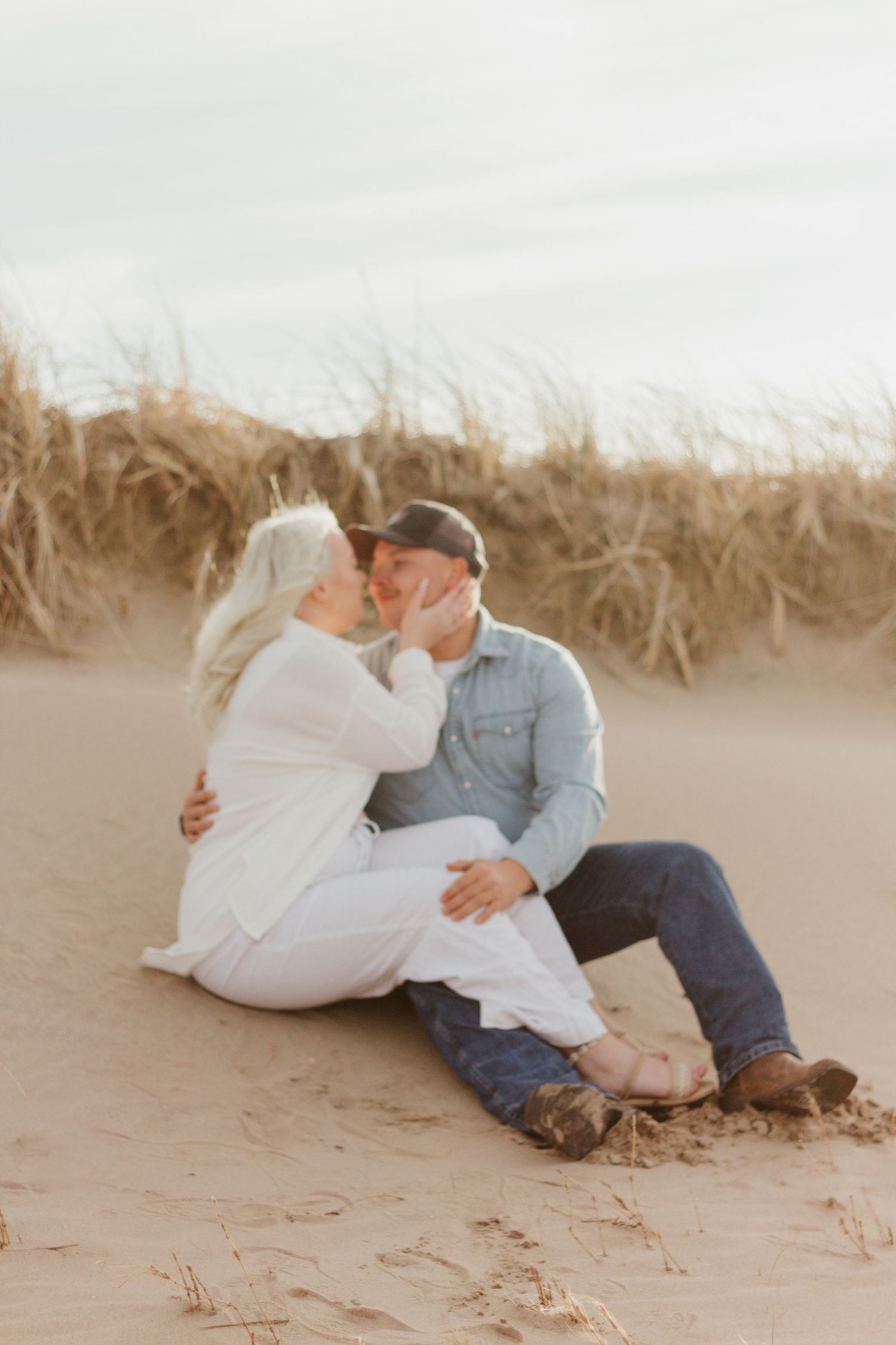 Romantic moment shared on sandy beach during sunset.