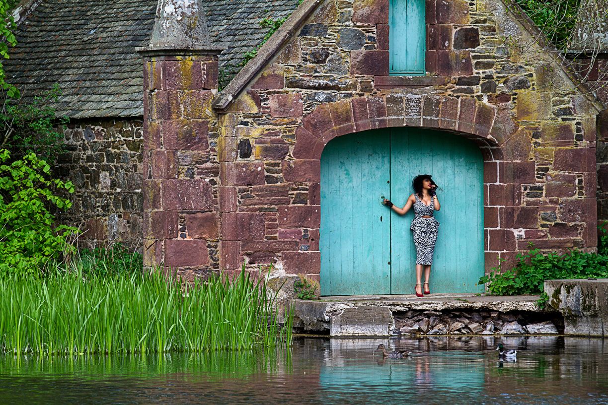 lady standing outside a boathouse on a lake