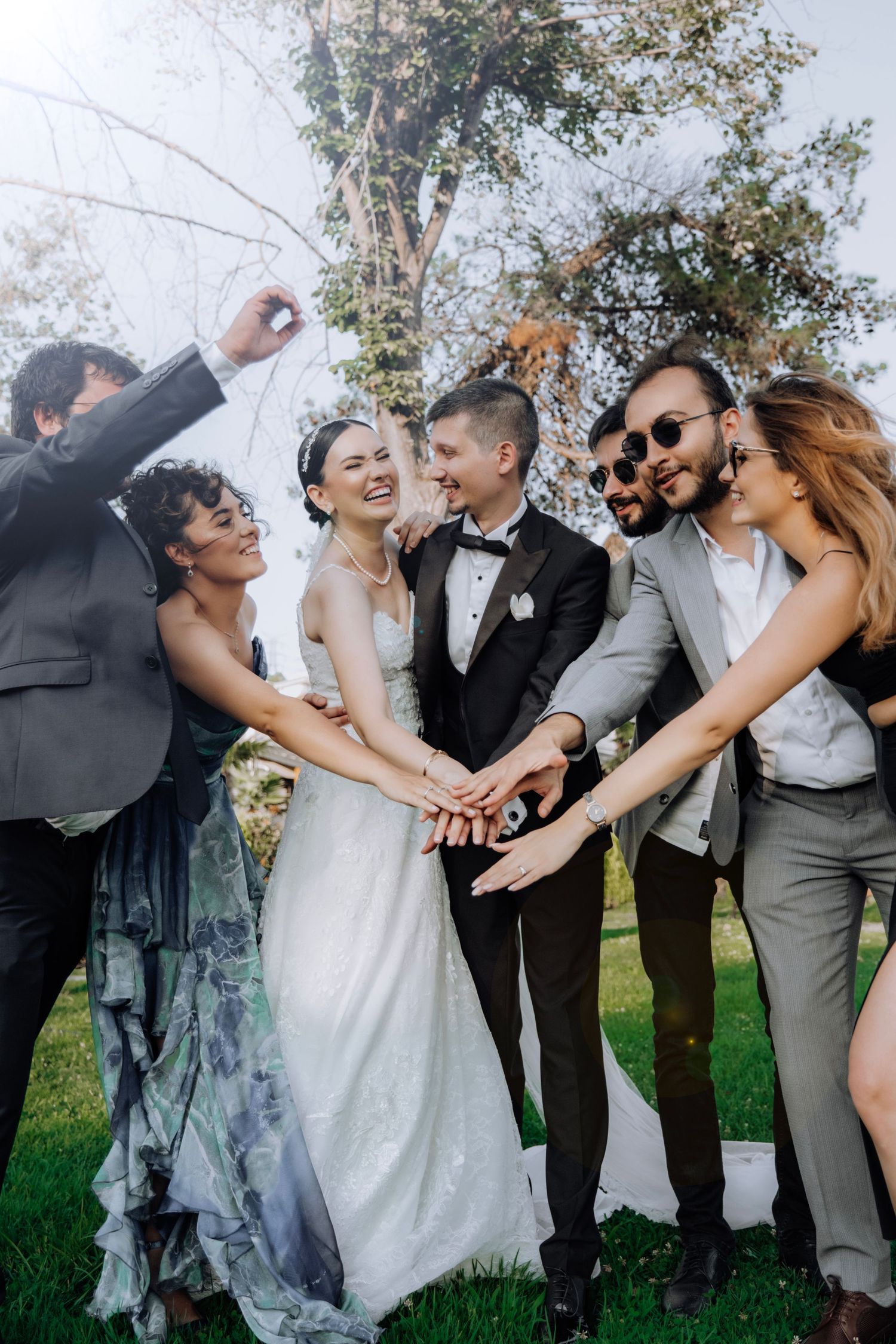 Bride and Groom with entourage holding hands and having a good laugh