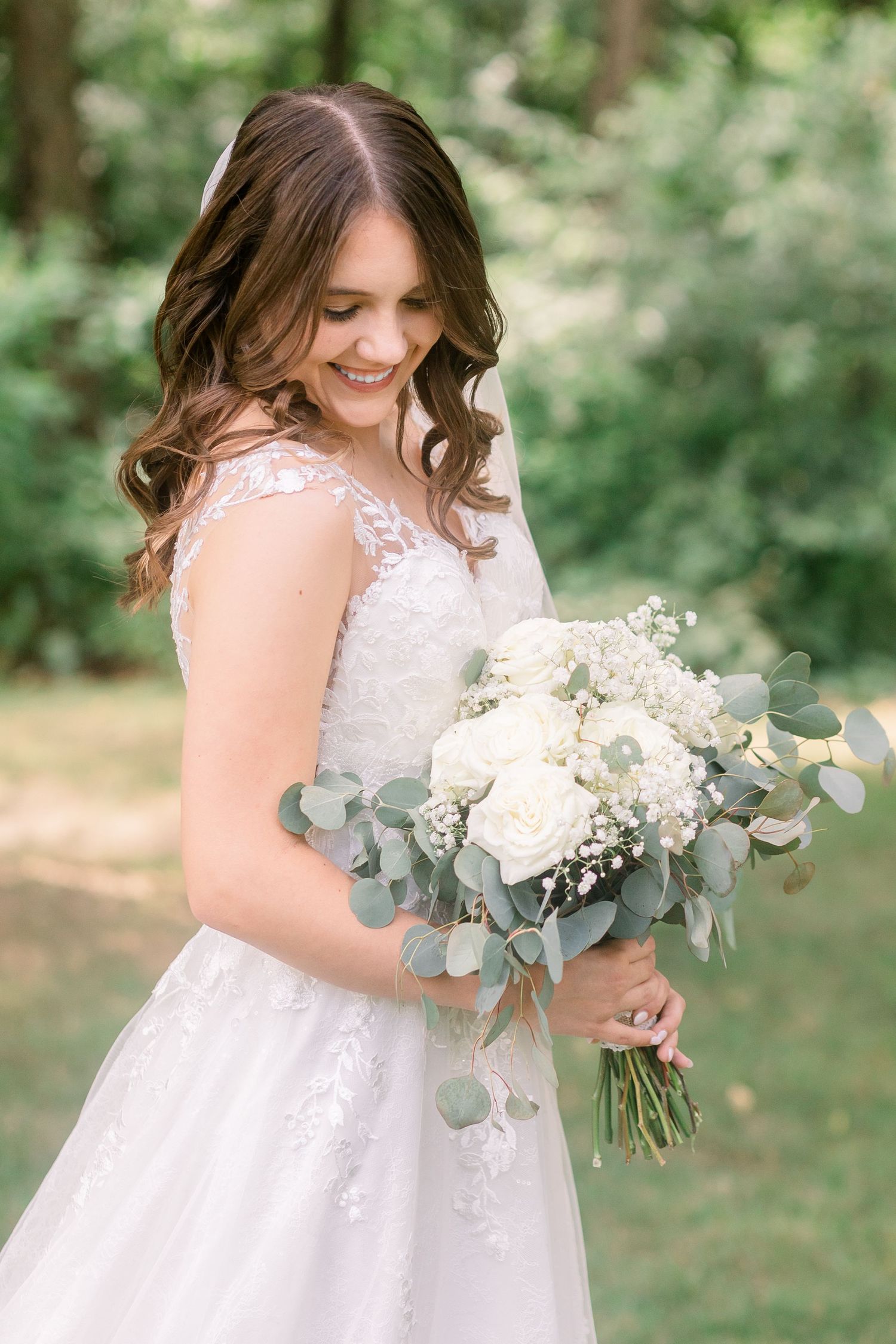 Close-up of white bridal bouquet with eucalyptus leaves and delicate flowers.