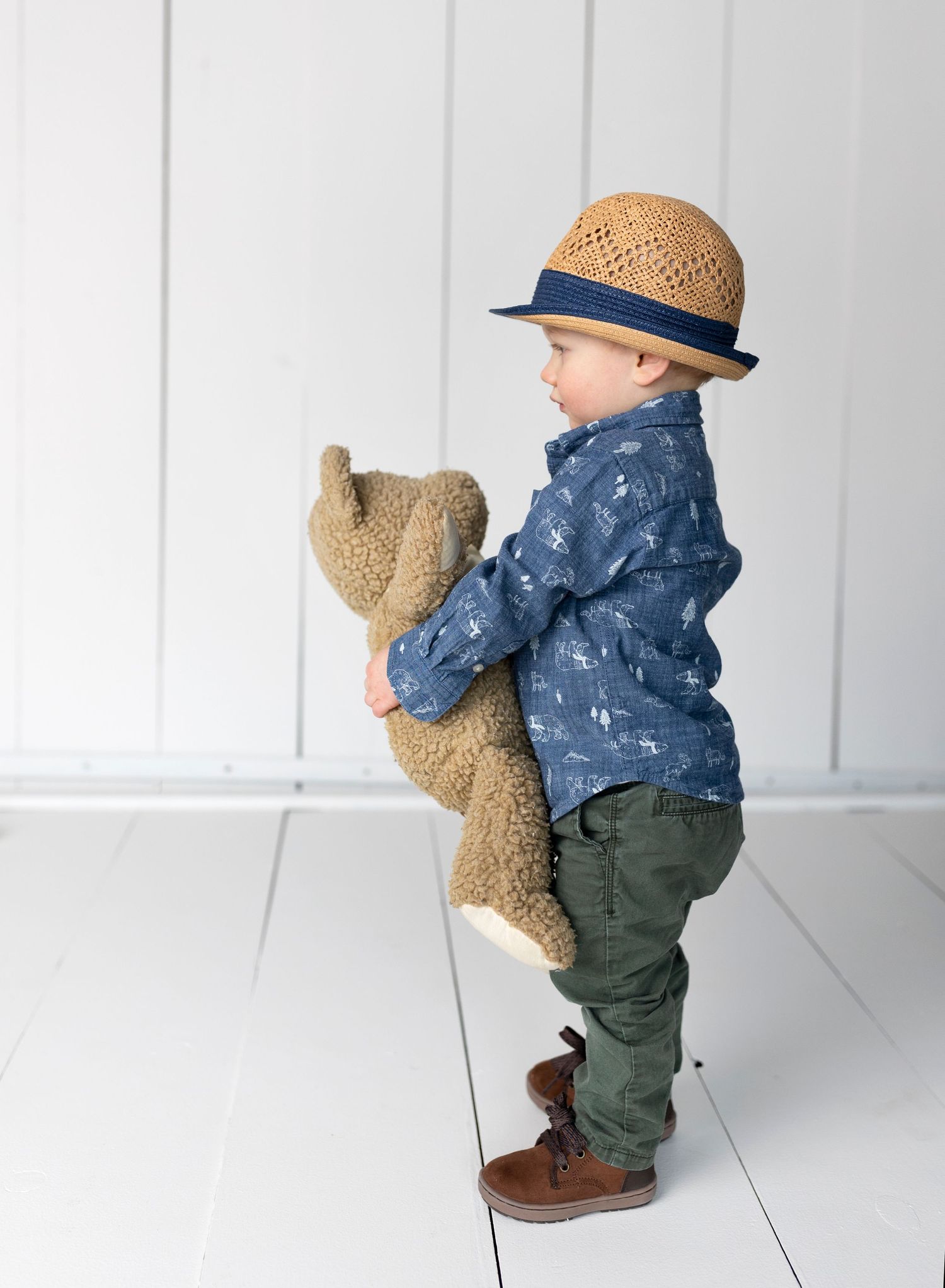 boy with hat and teddy on white background