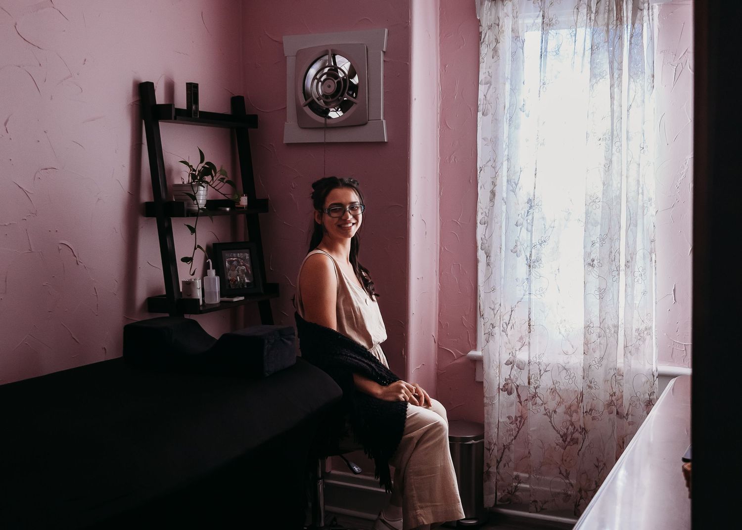 Pink room interior with ladder shelf, window, and natural light.