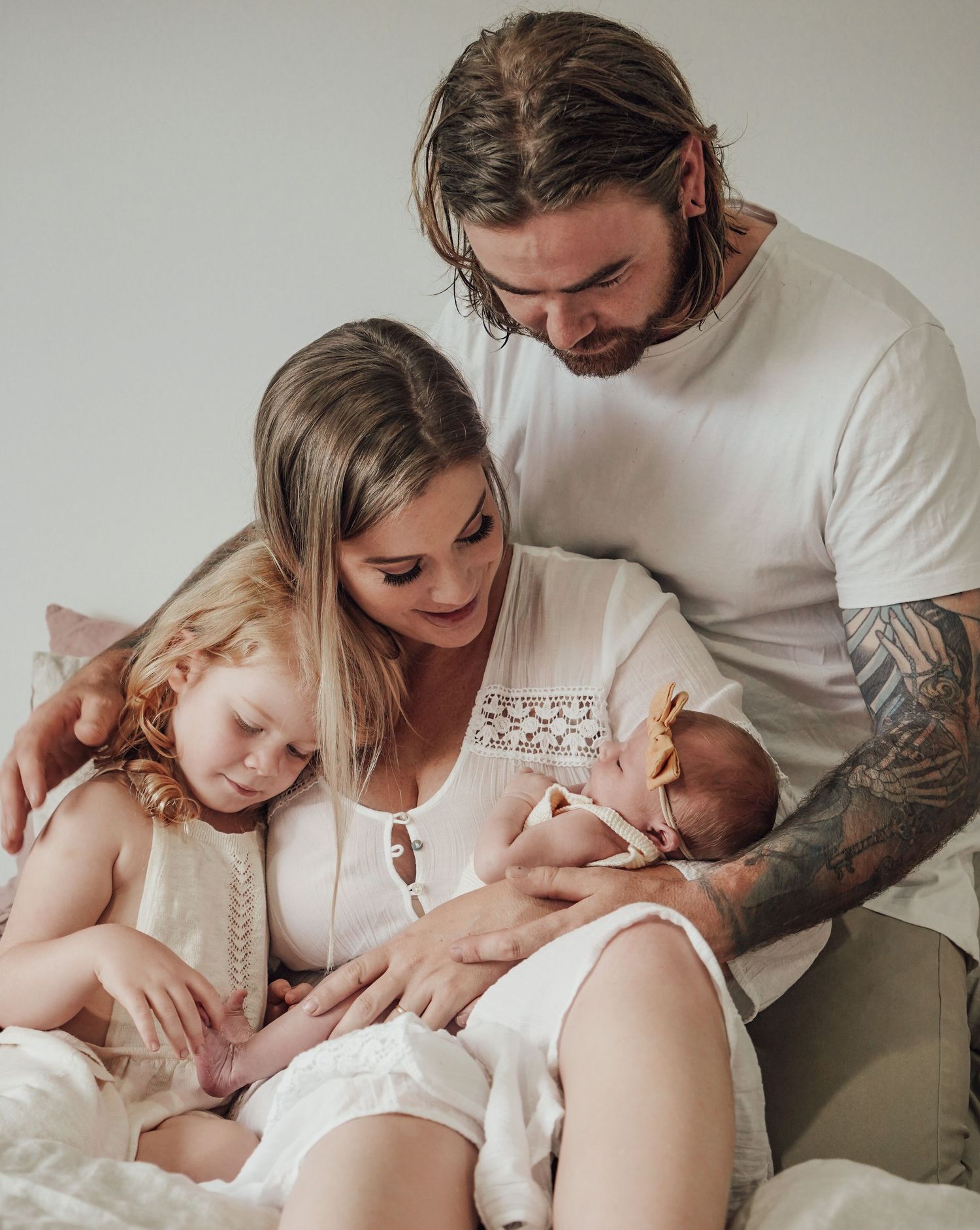 Intimate family moment as they welcome new baby in soft neutral tones.