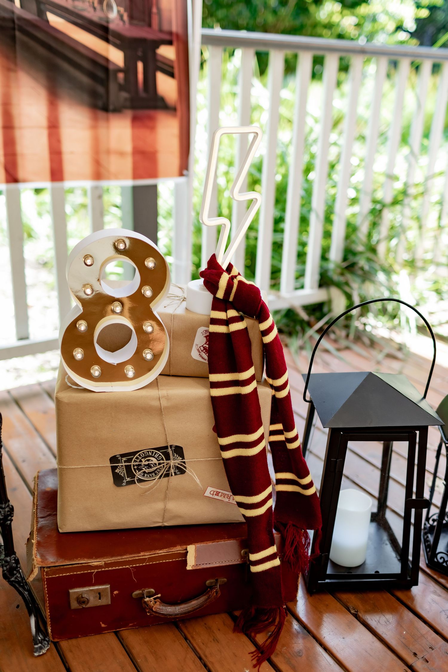 Harry Potter themed wedding decor with Hogwarts scarf, vintage suitcase, and decorative number 8.