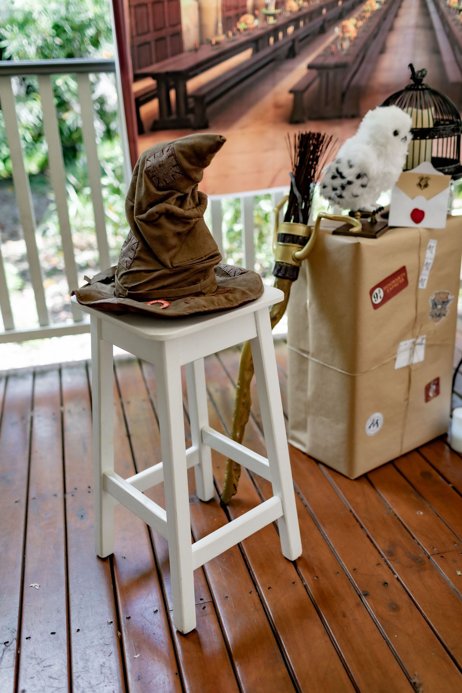 Sorting hat prop displayed on white stool with magical accessories and themed decorations.