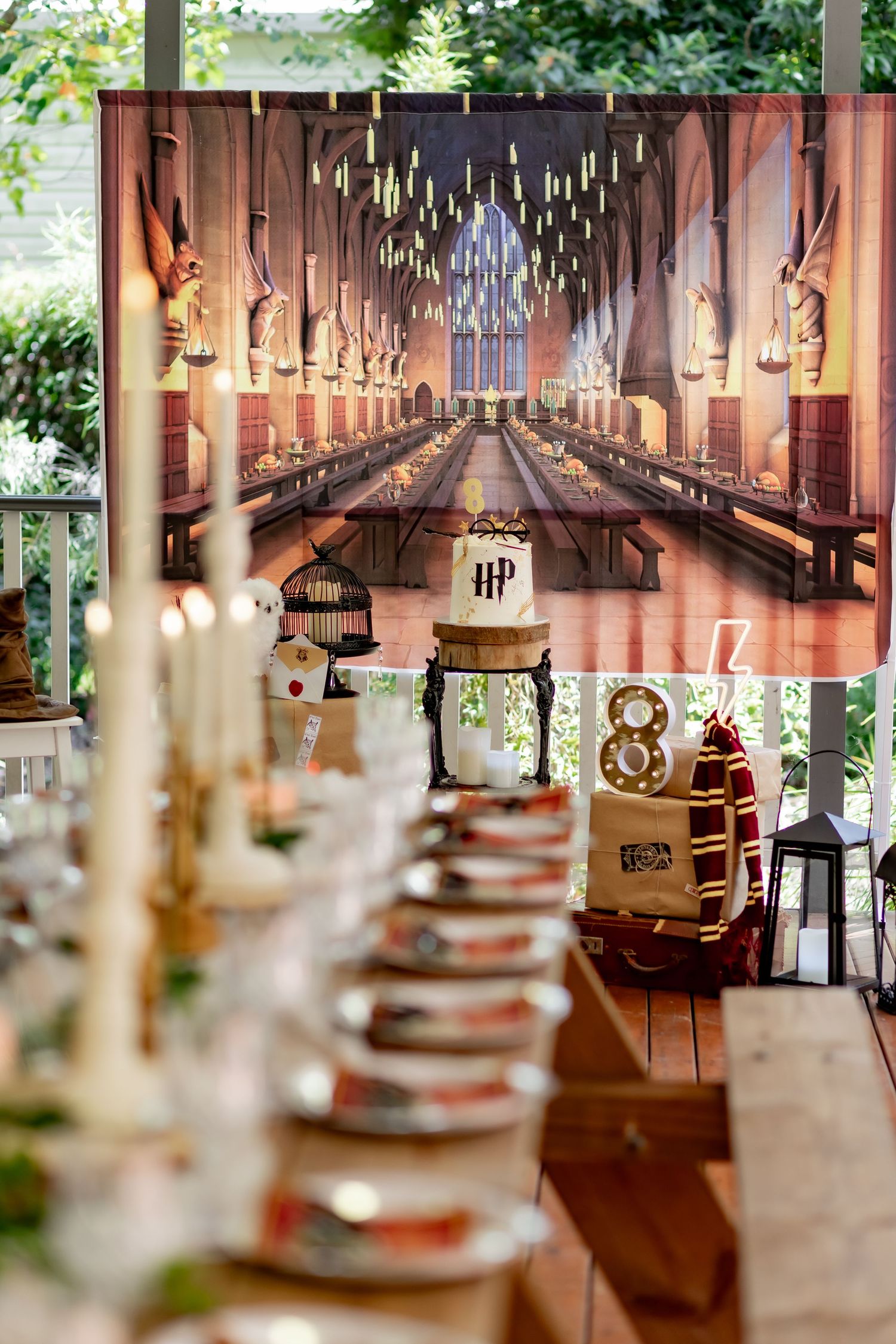 Harry Potter themed wedding reception table with magical Great Hall backdrop and floating candle decorations.