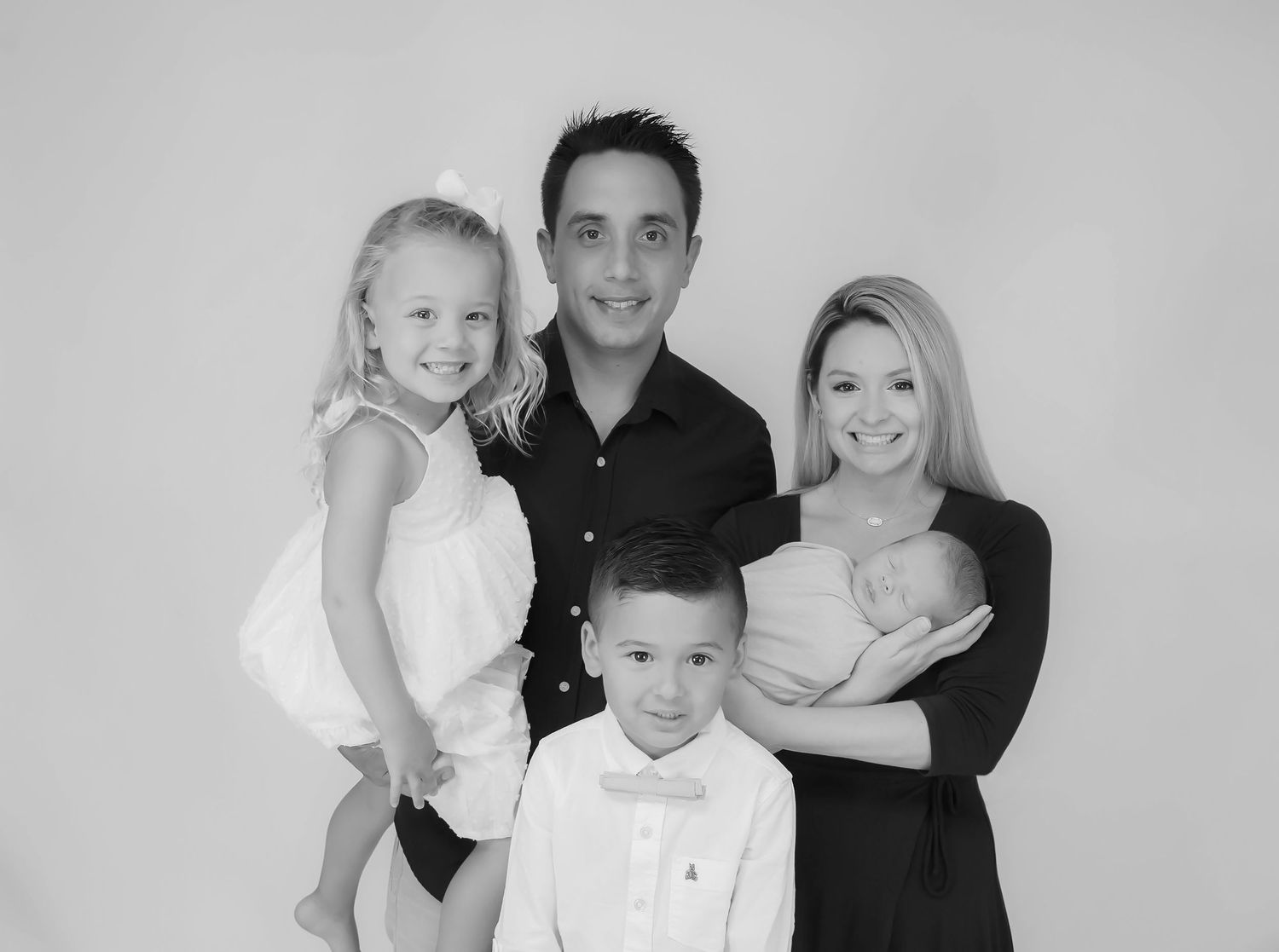 Classic black and white studio portrait of a family group.