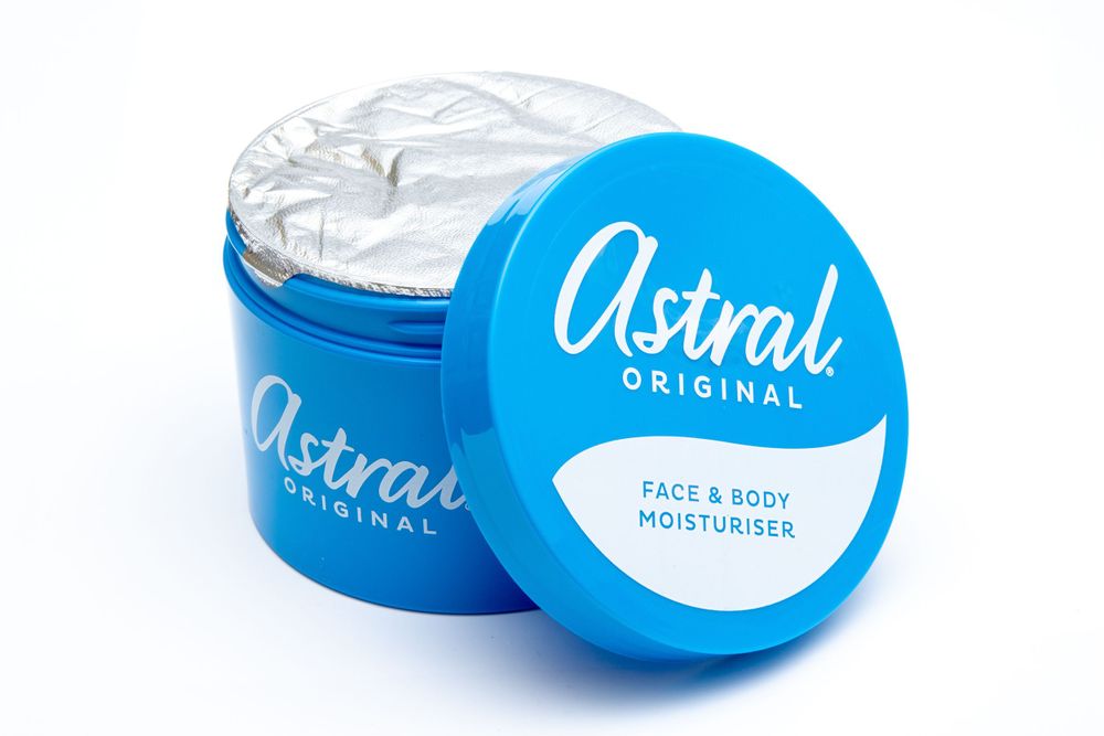 Blue jar of Astral face and body moisturizer with opened lid showing white cream.