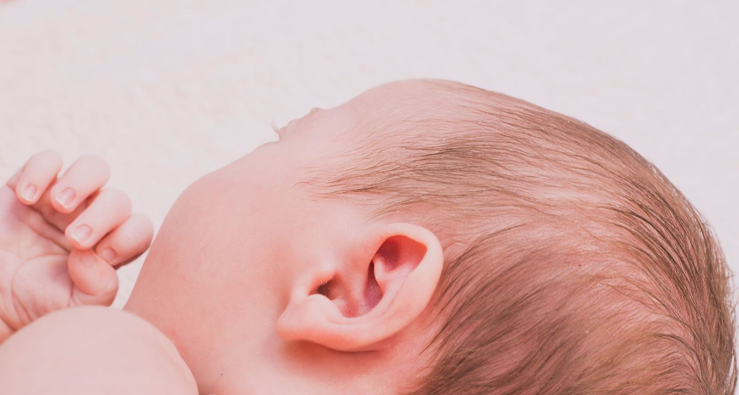 Gentle black and white close-up of a newborn baby's features in natural light.