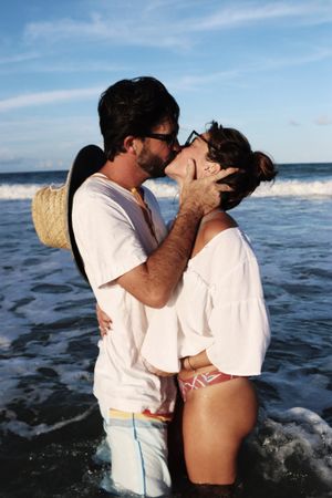 Woman and Man kissing in the ocean near beach