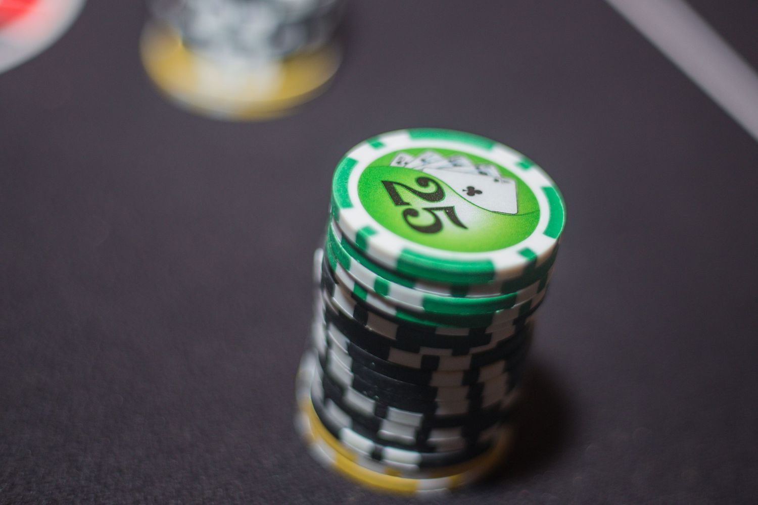 Close-up of casino poker chips stacked on a dark surface.