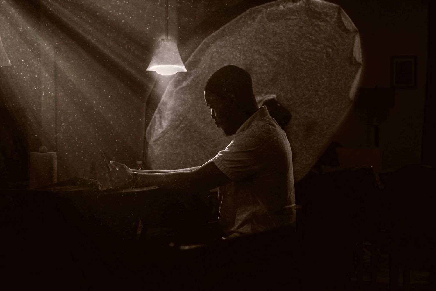 Dramatic black and white silhouettes of musicians performing on a dimly lit stage.