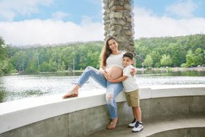 A tender moment between mother and child during a lakeside maternity shoot.
