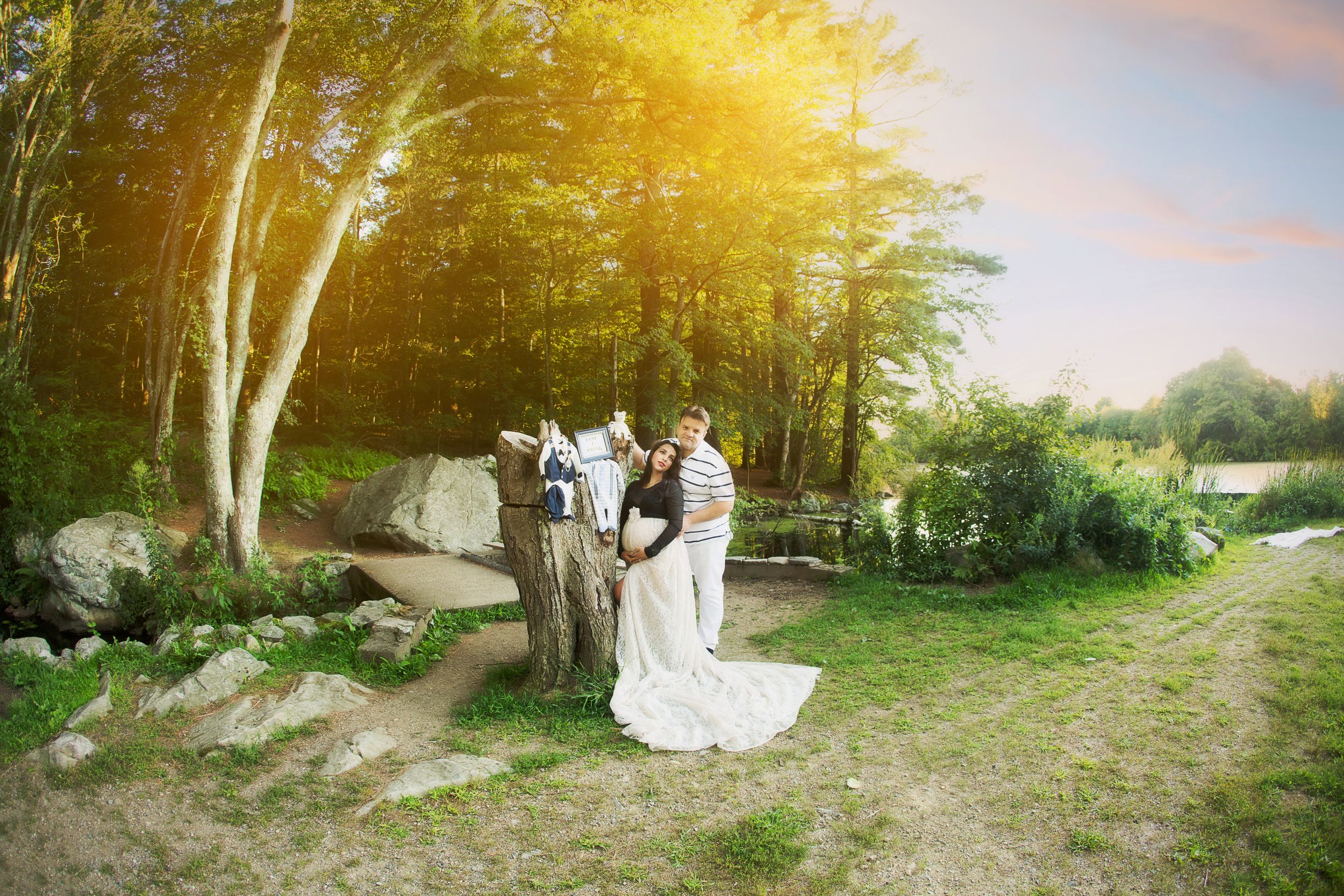A small wedding ceremony takes place on a rustic forest path during golden hour.