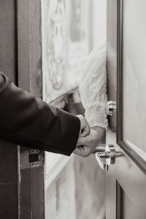 Close-up shots of hands opening and closing a modern door handle in sequence.
