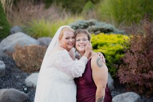 Wedding party poses for outdoor photos among landscaped gardens and natural scenery.