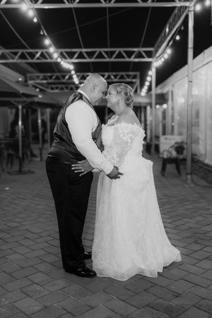 Black and white photo series of a couple dancing at night on a tiled outdoor venue.