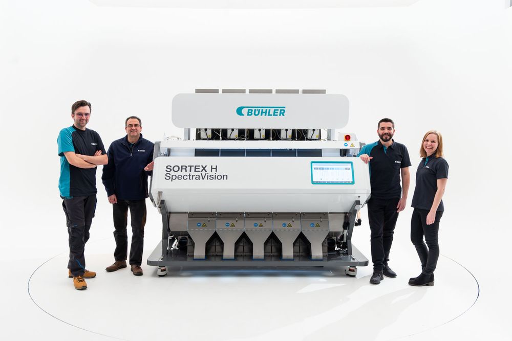 Professional commercial photography of Buhler staff with industrial machinery in a white studio.
