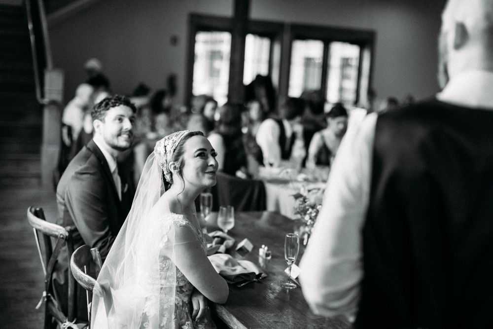 Black and white photo of wedding reception guests seated at tables.