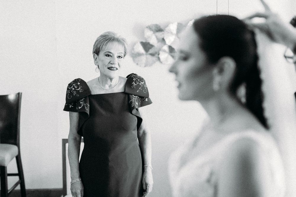 Black and white photo showing a heartwarming moment between mother of the bride and the bride during wedding preparations.